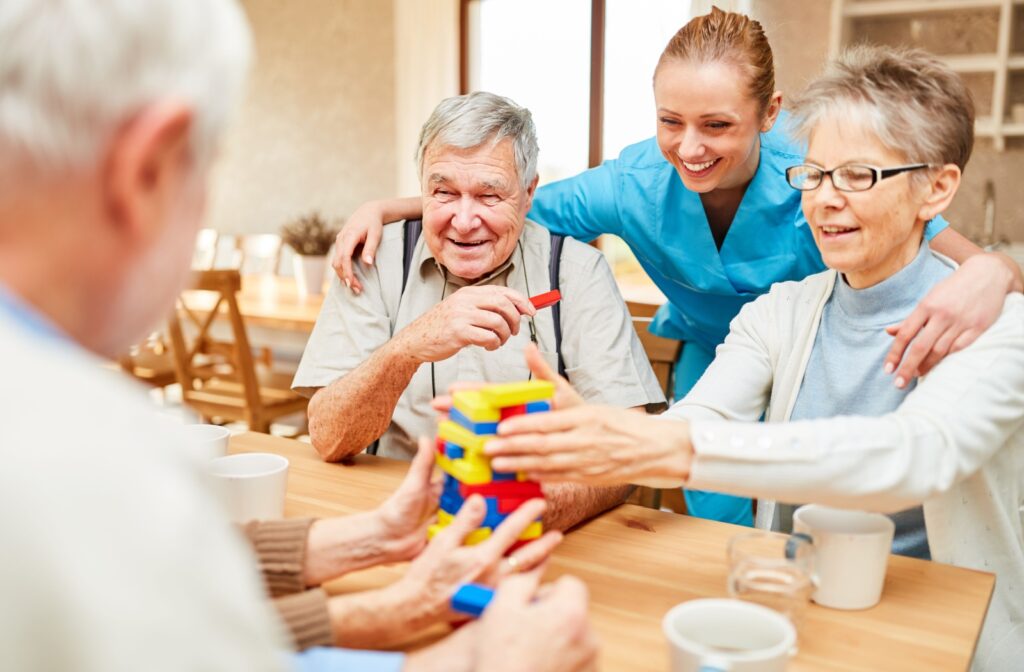 A group of seniors playing Lego with a caregiver assisting them