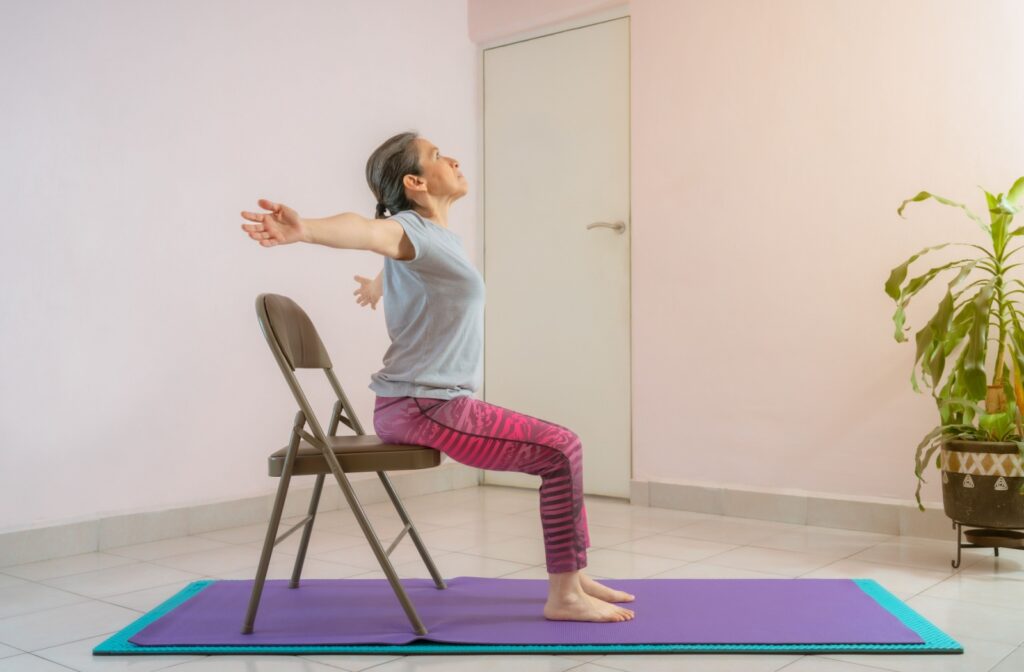 A senior performing gentle chair yoga exercises to maintain their physical fitness.