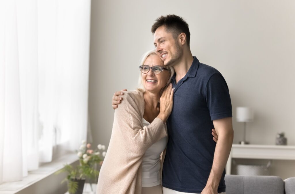 A son embraces his mother while visiting her in assisted living.