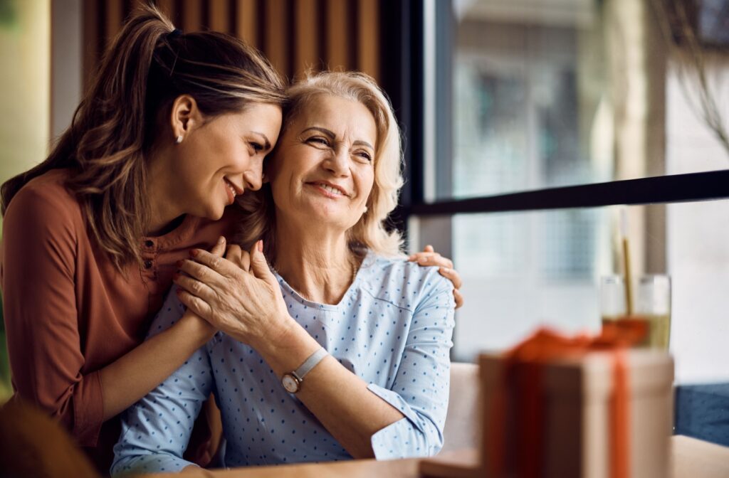 An adult child lovingly hugs their senior parent, offering support and comfort as their loved one transitions into an assisted living community.